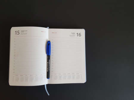 Grodno, Belarus-11.07.2020: Notepad and pen on a black isolated backgroundのeditorial素材