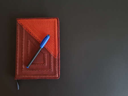 Notepad and pen on black isolated background