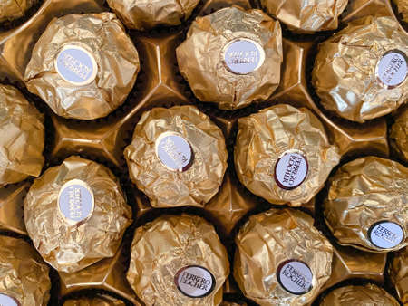 Grodno, Belarus - 03.09.2021: Background of golden Ferrero Rocher candies close-up. Texture of Ferrero Rocher candies.のeditorial素材