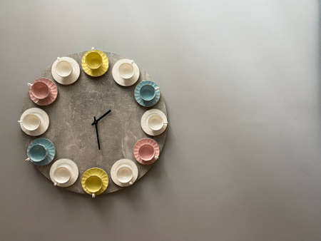 Cup and saucer clock hanging on the wall close up with mockup