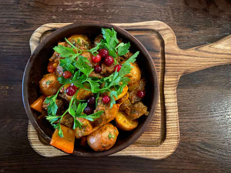 Ojahuri with veal in a brown plate is served on a plate and stands on a wooden tableの写真素材