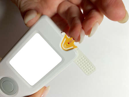 Measurement of blood sugar levels using a glucose meter with a mock-up. Piercing a finger to draw...