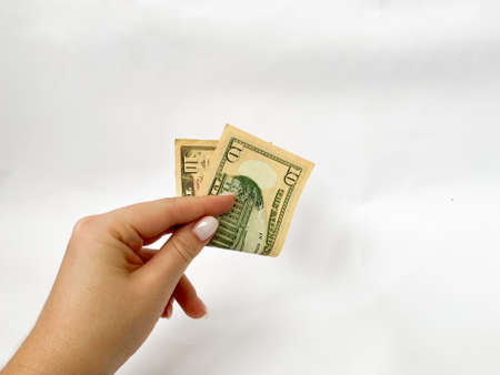 10 dollars in the hand close-up on a white isolated background. A ten-dollar billの写真素材