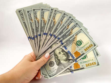 A bunch of dollars in the hands of a close-up. The background is made of dollars. Isolated dollarsの写真素材