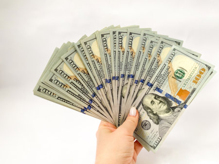 A bunch of dollars in the hands of a close-up. The background is made of dollars. Isolated dollars