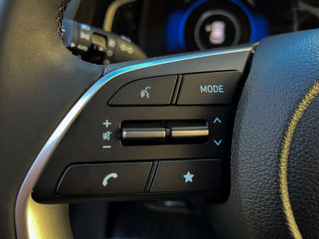Interior of the car with cruise control buttons, voice communication on the steering wheel