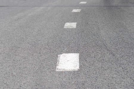 road markings. An intermittent white stripe on an asphalt road. urban transportの写真素材