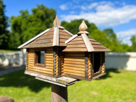 Wooden bird feeder in the form of a house with baitの写真素材
