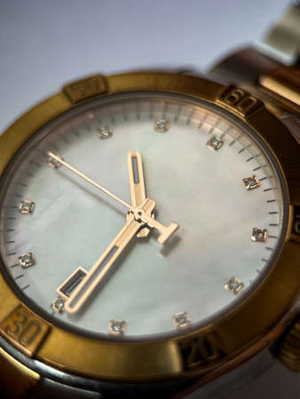 Luxury stainless steel watch with chronograph, white dial and metal bracelet close-up....