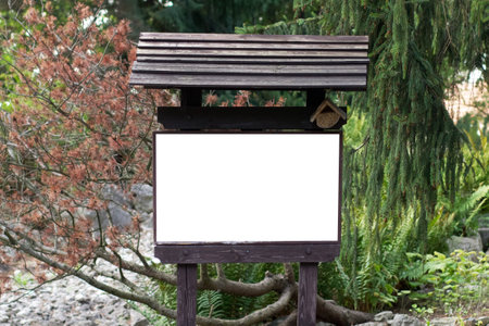 A white sheet of paper on a wooden information carrier with a mockup installed in a forest parkの写真素材