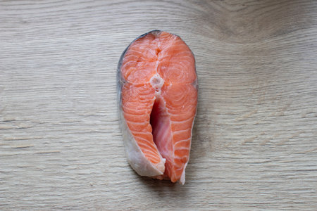 A salmon steak lying on a cutting board close-up