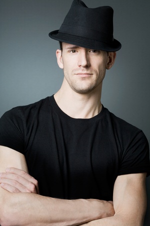 Young handsome man posing in black t-shirt and black hat.の写真素材