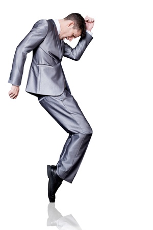 Young handsome businessman in silver suit dancing. Isolated.の写真素材