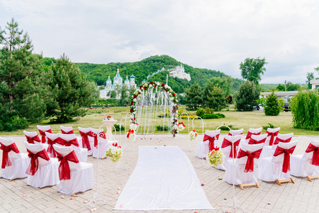 Arch for the wedding ceremony, decorated with cloth flowers and greenery, is on mountains backgroundの写真素材