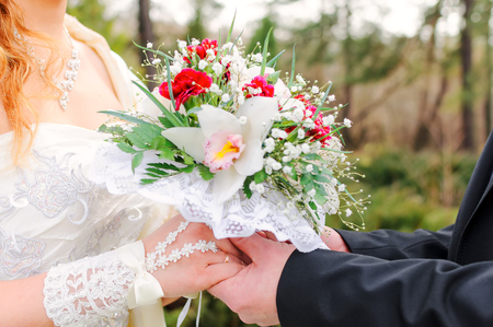 The groom holds the bride by hands. Couple holds hands at a ceremony. Wedding day.の写真素材