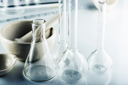 Flasks and vessels of a chemical laboratory. Table with equipment lab. Top view from head.の写真素材