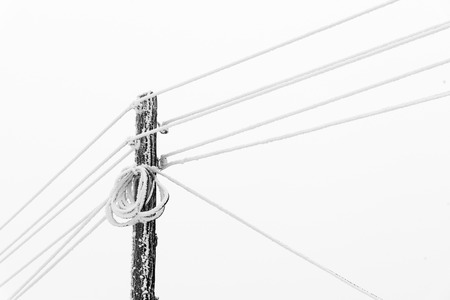 Electrical Power pole with wires in the winter frost. Freezing high-voltage line. Frozen Electrical...
