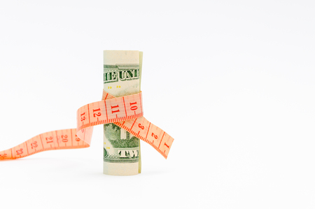 Compression of the budget of financing. Financial concept. Measurement of a banknote of twenty dollars ruler. Dollar banknote and measure tape.の写真素材