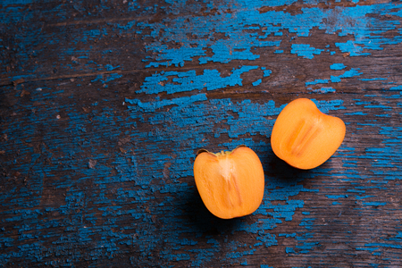 Persimmons fruits slice on old wooden table. Food background top view blank space for textの写真素材