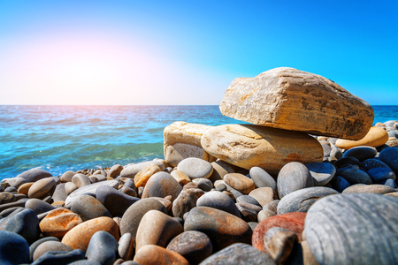 Stones on the seashore. Beach pebbles. Large stones on the beach on a sunny clear summer day. Activities at the resort.の写真素材