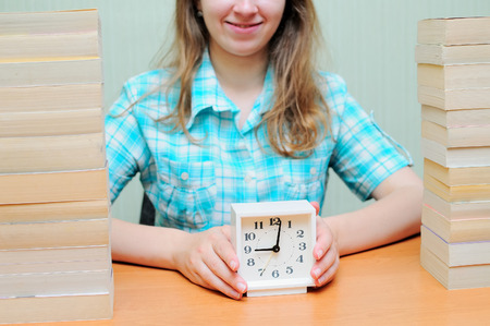 Smiling girl students read book. Pretty woman hold watch.