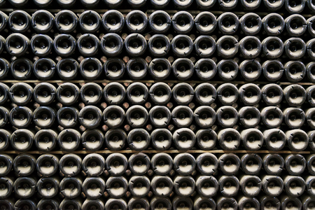 Background bottles wine. Bottles of sparkling wine in a cellar are put at each other.