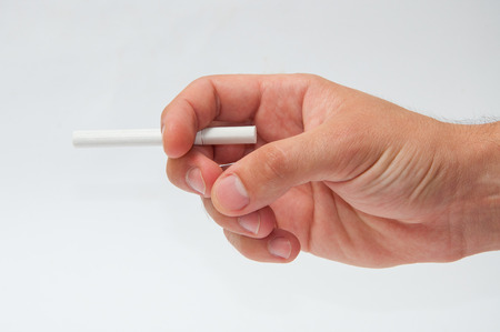 Men's hand holds a cigarette on a white background isolatedの写真素材