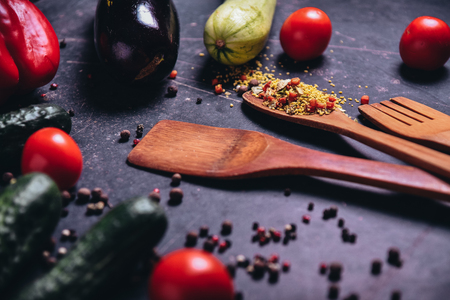 Vegetables - zucchini, cucumber, tomatoes, spices, pepper on a dark table.の写真素材