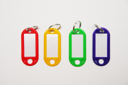 Keychain, red, yellow, green, blue colors on a white background. Different key label blank on white background. Empty copy spase.の写真素材