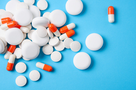 Vitamin and antibiotic, pill and tablets on blue background. Medicines healthcare concept.の写真素材