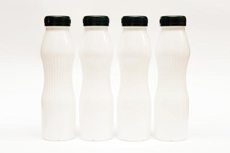 White plastic milk bottles on a white backgroundの写真素材