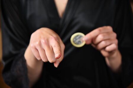 The girl propose a partner a condom. Condom, contraceptive in the hands of a girl.