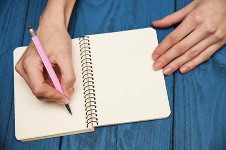 Girl writing in notebook, over head viewの写真素材