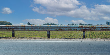 Solid old rusty road safety rail on highway roadside on blue sky background front viewの写真素材