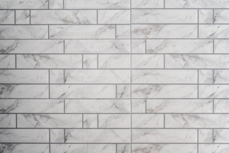 White wall with marble tiles and a white background in the style of linear patterns. Bathroom tiled...
