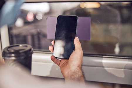 Smartphone in hand of a man close upの写真素材