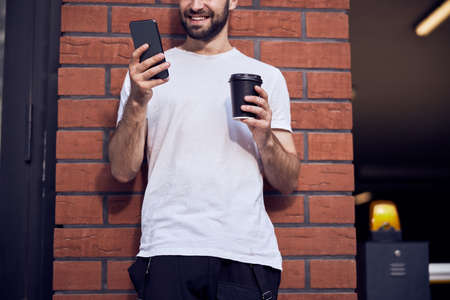 Man is sittiing  with phone in mask