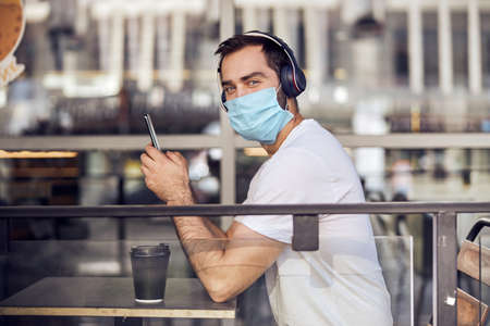 Man is sittiing  with phone in maskの写真素材