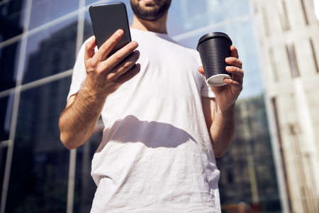 Man is sittiing  with phone in mask