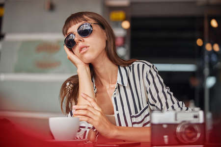 Young woman photographer after working in cafe