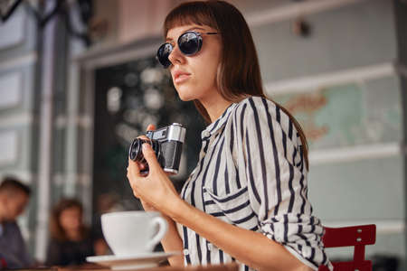 Young woman photographer is taking photo the long-awaited moment outdoorの写真素材