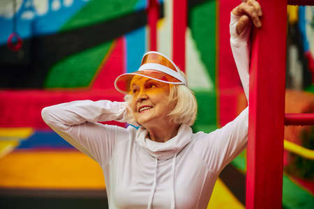 Old, healthy and cheerful lady on a colorfull square outdoorsの写真素材
