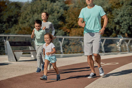 happy healthy and sporty family are doing workout trainings in sunny dayの写真素材