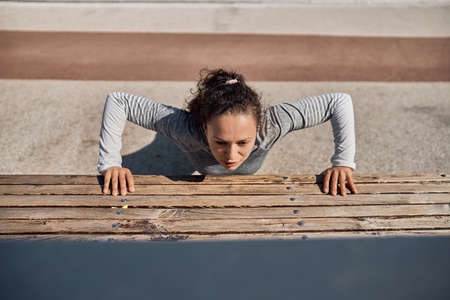 happy healthy and sporty woman is doing workout trainings in sunny dayの写真素材