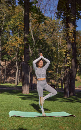 happy healthy and sporty woman is doing yoga trainings in sunny dayの写真素材