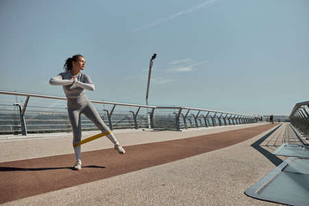 happy healthy and sporty woman is doing workout trainings in sunny dayの写真素材