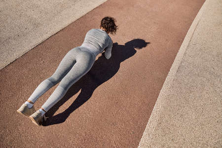 happy healthy and sporty woman is doing workout trainings in sunny day