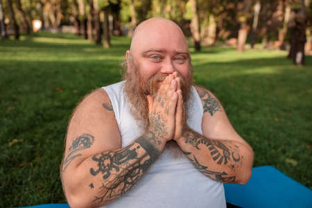 Fat caucasian bearded and bold man is doing morning exercses to loose his weightの写真素材