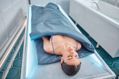 Beautiful healthy smiling caucasian woman is doing beauty procedures at spa and healthcare salonの写真素材