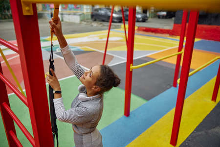 Beautiful healthy cheerful smily woman workout in an urban color city training square